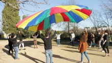 un groupe d'agents s'amuse avec le jeu du parachute coopératif