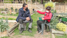un enfant interview un adulte dans le potager
