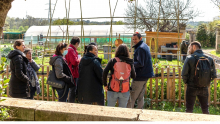 un agent et un groupe d'adulte observent le jardin des possibles de l'Écolothèque