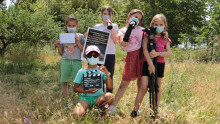 5 enfants posent avec leurs accessoires de tournage : prompteur, clap, trépied, fiches...
