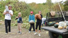 Un animateur et 3 enfants récoltent des courges