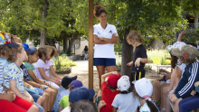 Un groupe d'enfants discute avec la nageuse Coralie Balmy