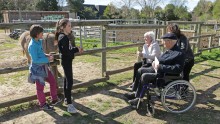 Des enfants explique à des retraités le fonctionnement de la ferme