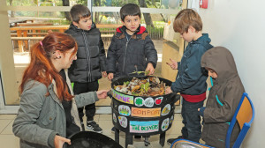 Une animatrice et quatre enfants sont autour d'un vermicomposteur