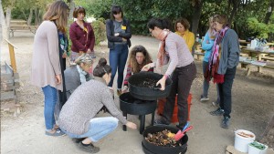 un groupe d'adultes ouvre un vermicomposteur pour voir les étages